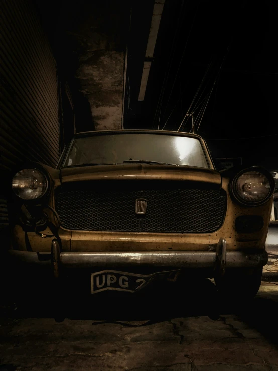 an old car is parked in a dark area