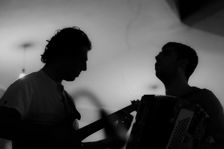 two men playing music and singing together