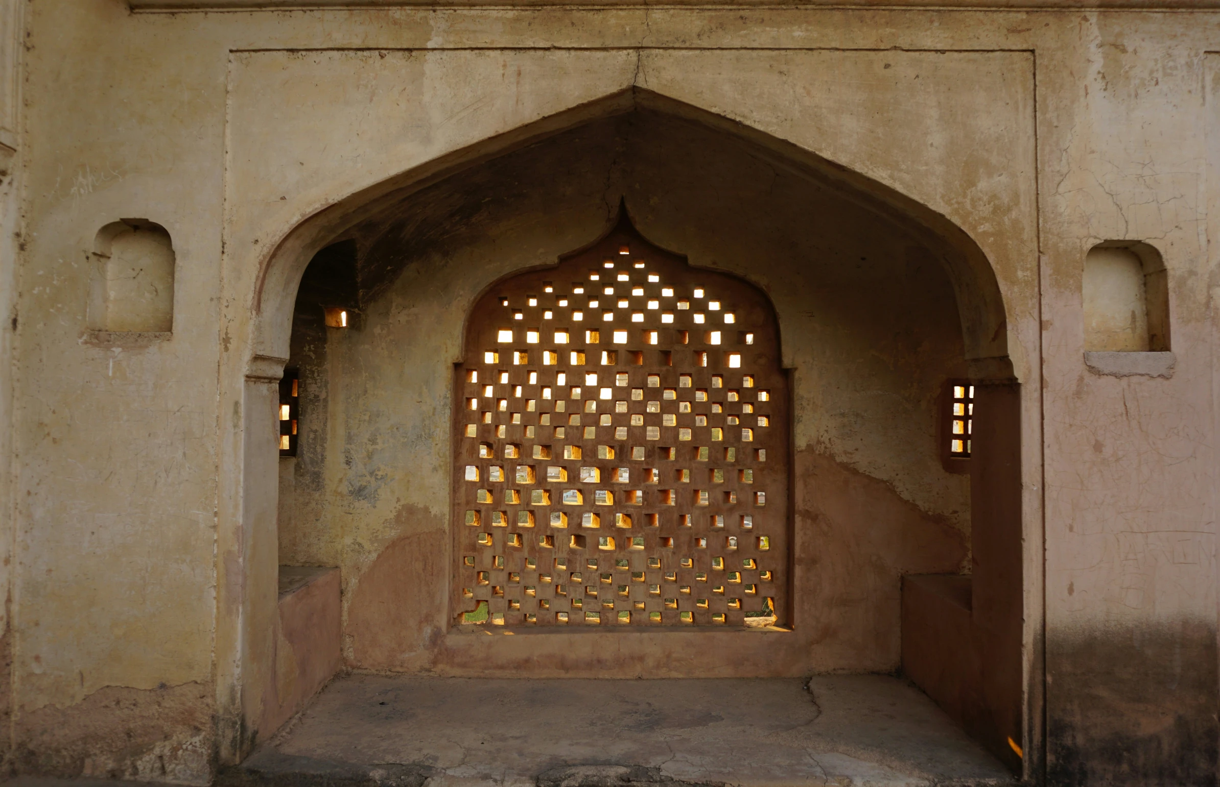 arched window in an old wall with some light on it