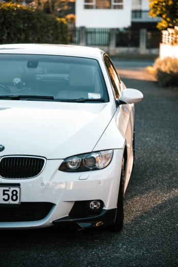 a white bmw coupe parked on the road