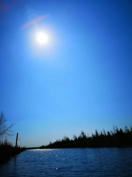 the sun shining over a body of water