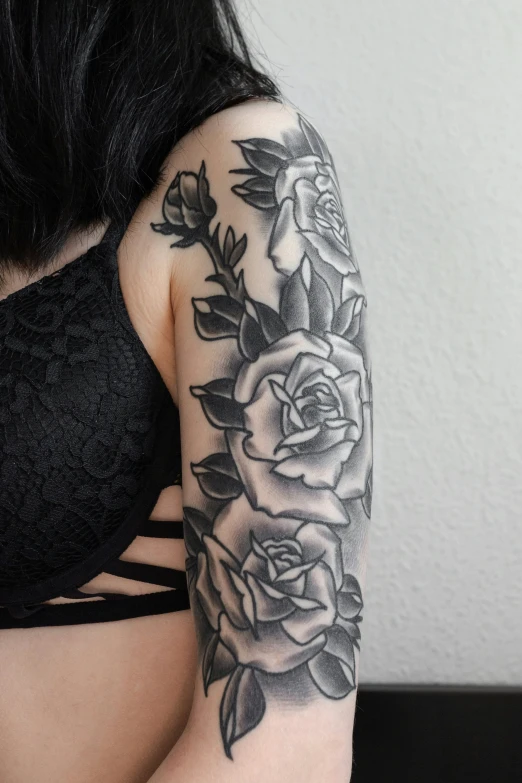 a very close up of a womans arm with some roses on it
