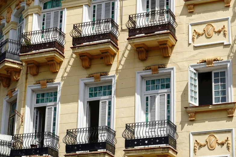 an ornate building with balconies and shutters on a sunny day