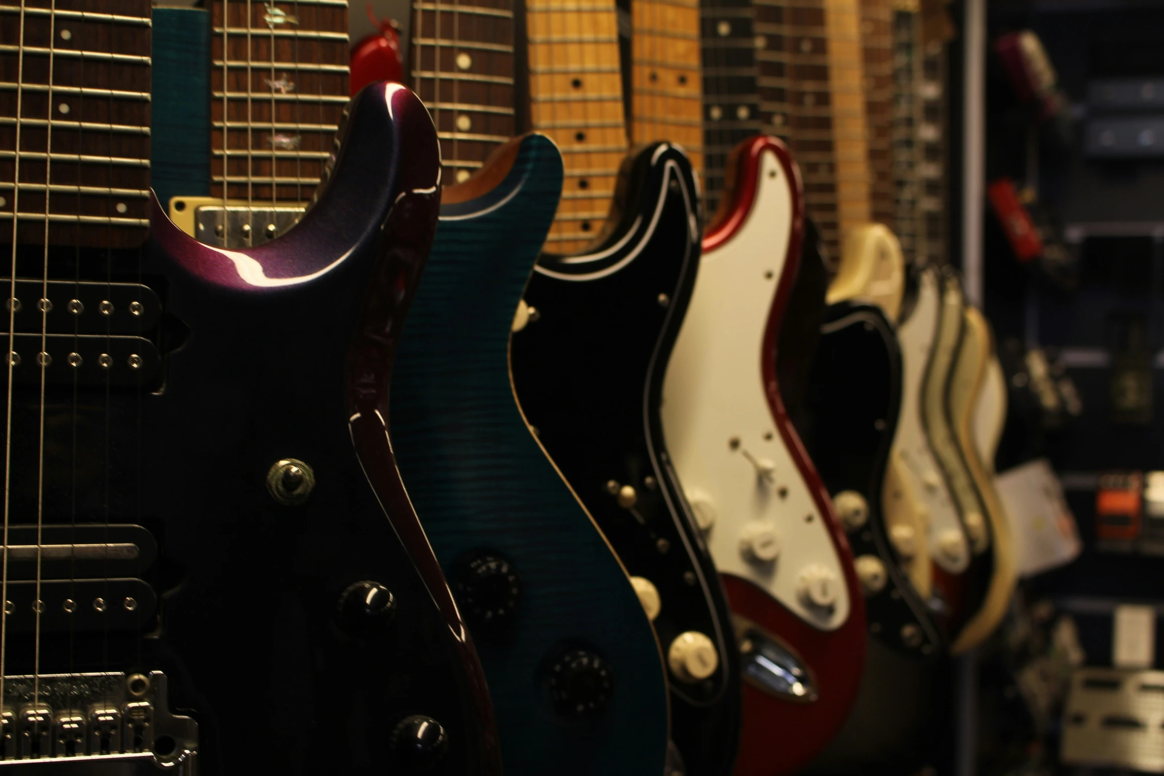 guitars lined up for sale on display at the store