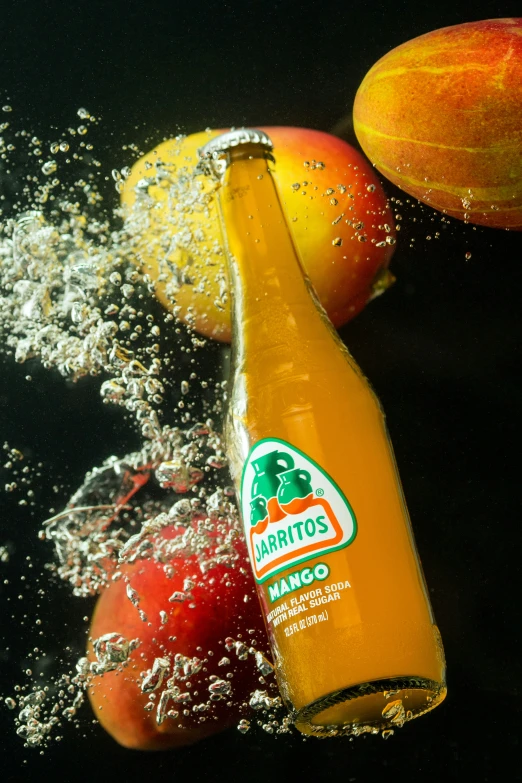 two apples falling into the water next to a bottle