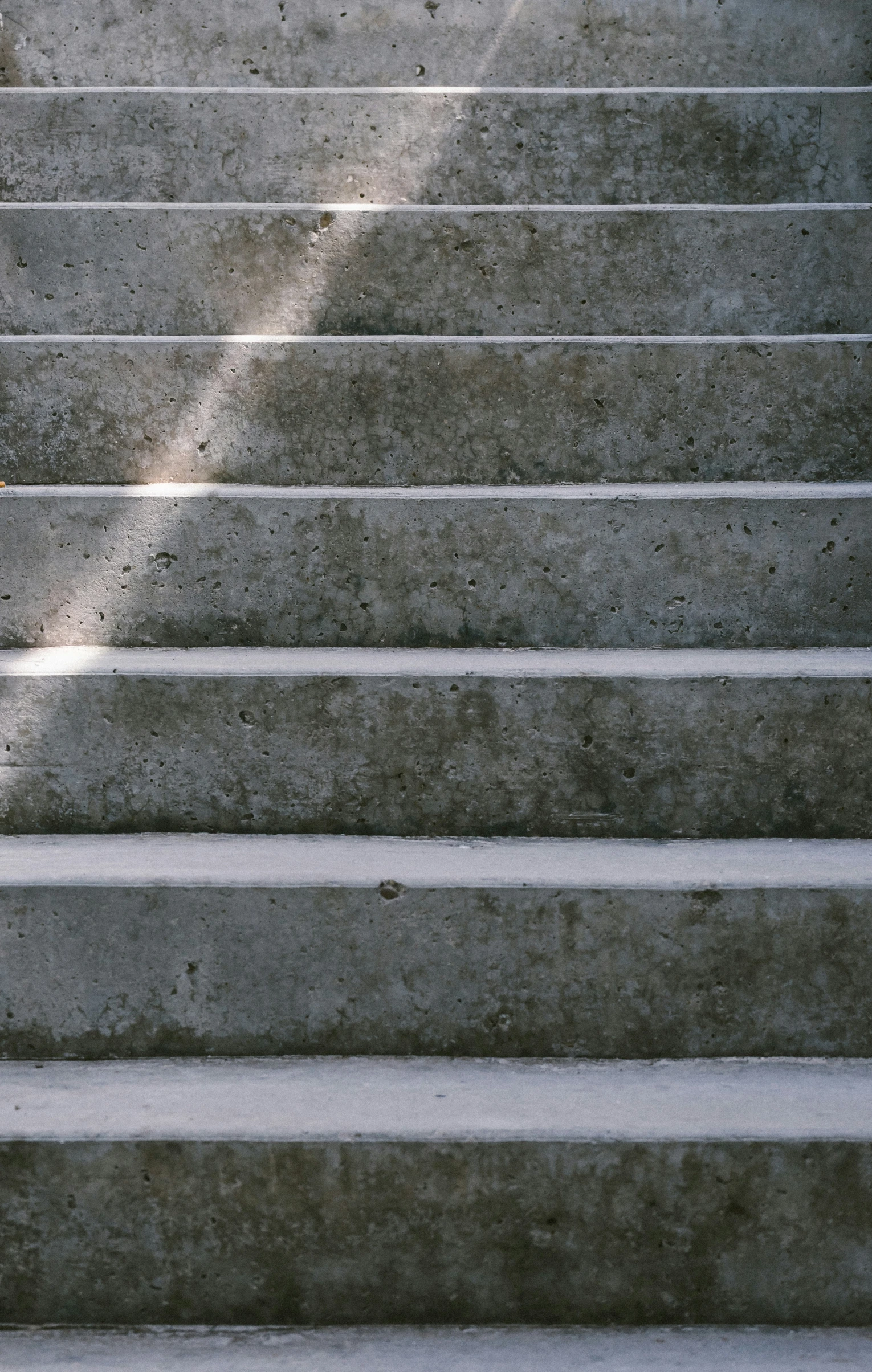 a young person with a skateboard sits on steps