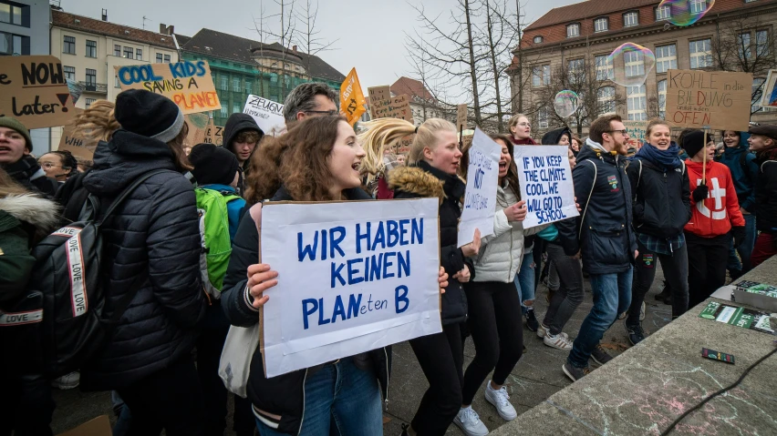 several women hold up signs in front of a crowd