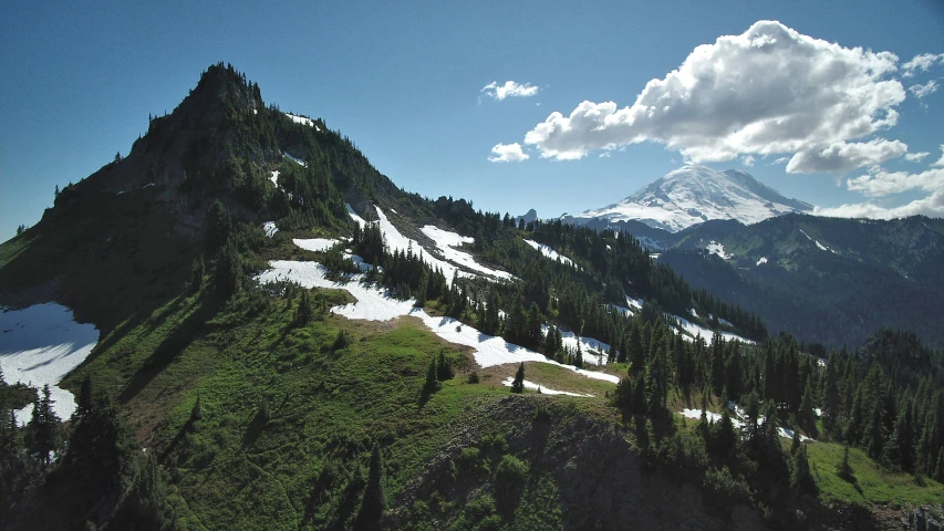 a snow - covered mountain, with clouds over the top