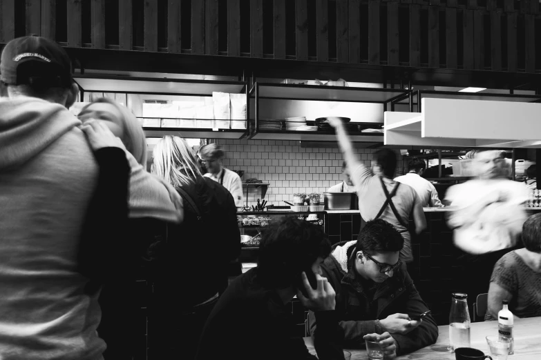 a restaurant kitchen with a few people seated around the counter