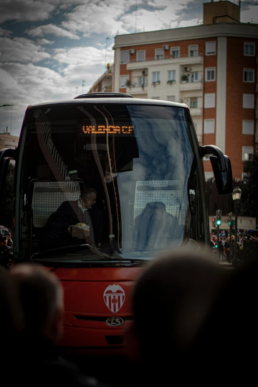 a red city bus drives down the street