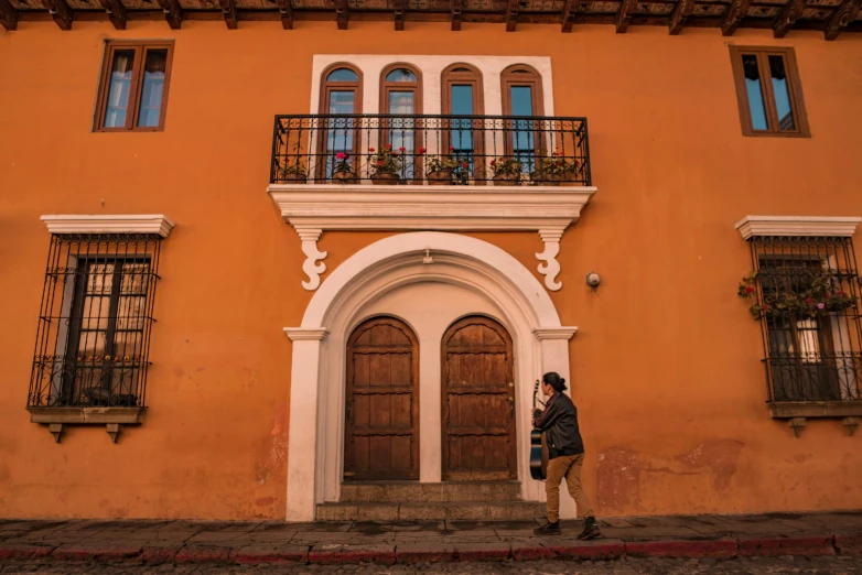 a woman stands outside of the entrance to an old building