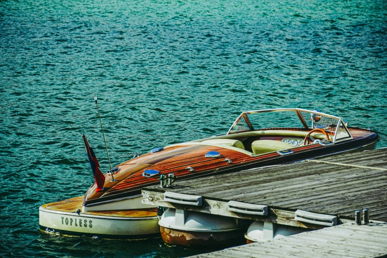 a small speedboat at a wooden pier in the water