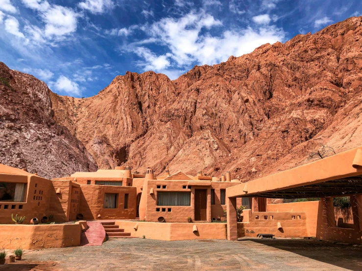 a large building made of adobe brick sitting under mountains