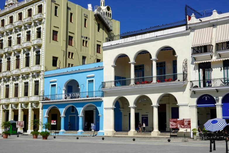 several buildings with white arches and blue, yellow and red