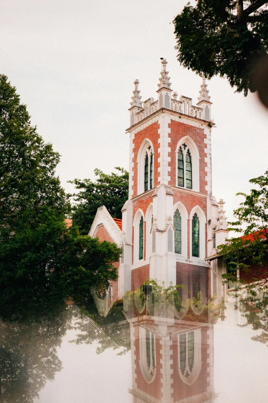 a red and white clock tower next to many trees