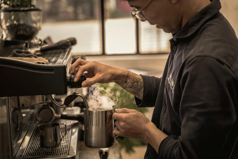 a man in glasses is holding a coffee cup