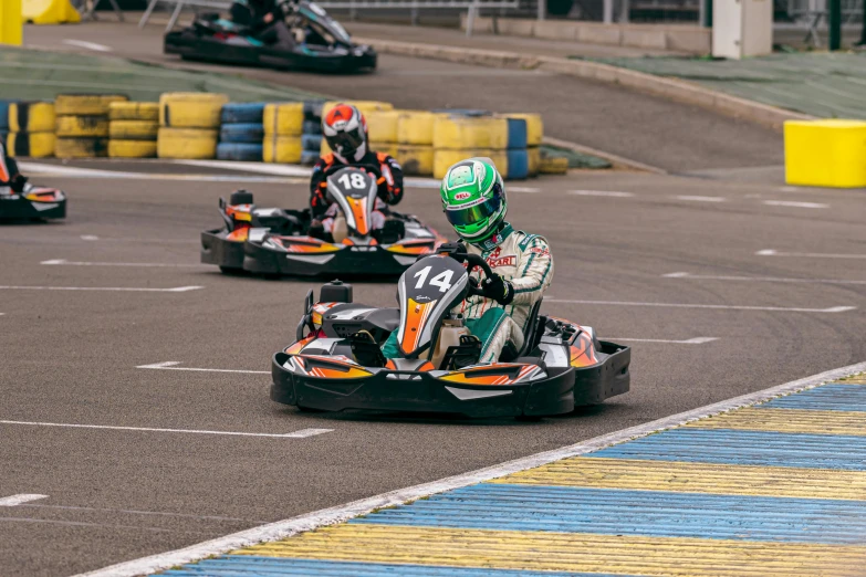 three men are racing on karts in a track