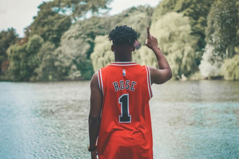 a man standing in front of a lake pointing at soing