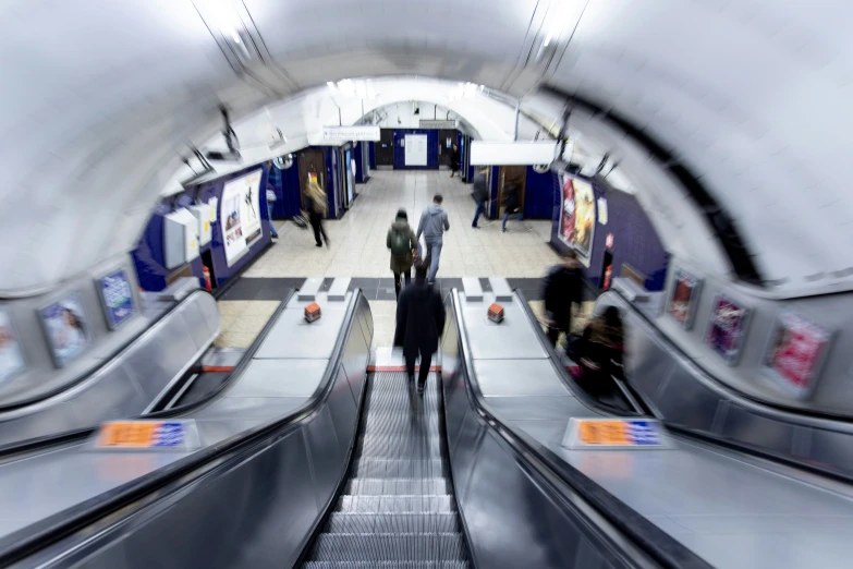 people riding an escalator inside a subway station