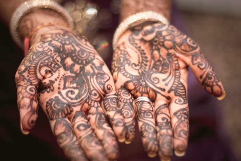 two hendi tattoos are held up by the hands of someone