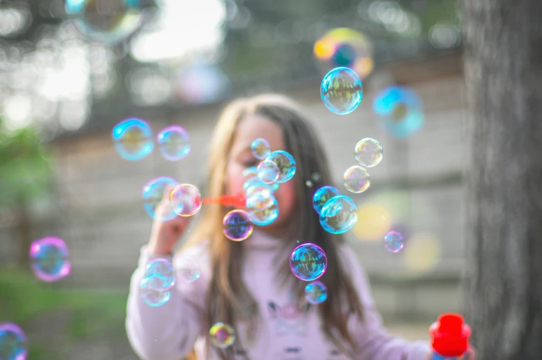 a  blowing bubbles off of her hair