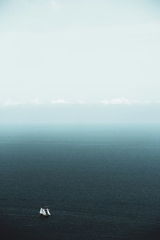 a ship sailing in the ocean with a blue sky