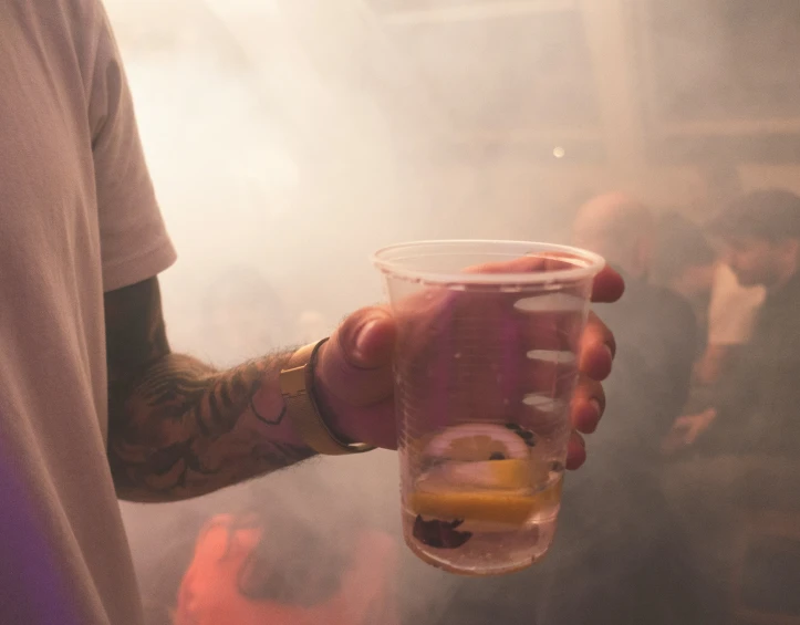 someone pouring alcoholic drinks into a cup