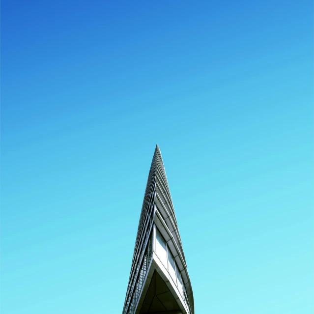 a building with a triangular structure on top against a blue sky