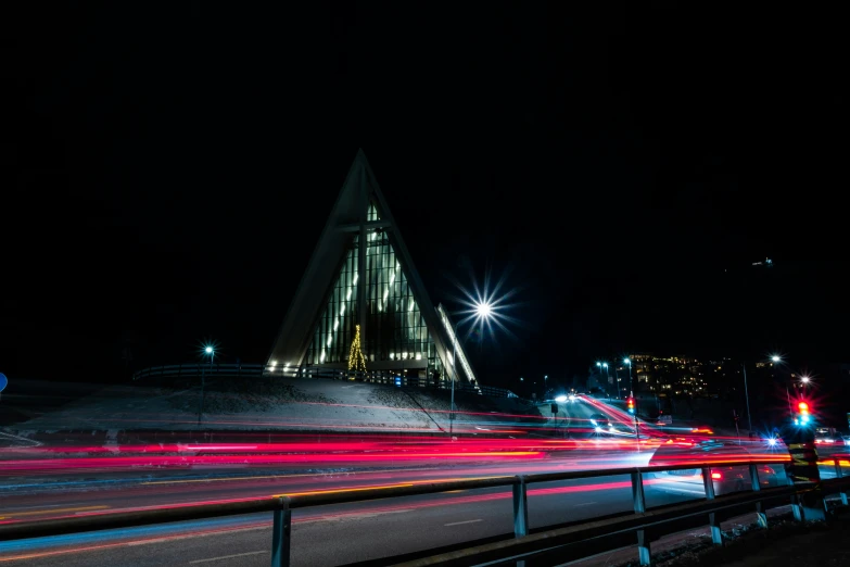 blurry pograph of a street at night with a church in the background