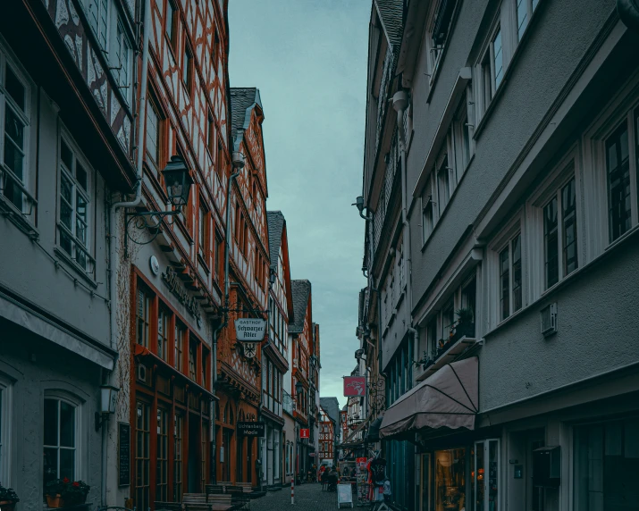 people walking down the middle of a narrow city street