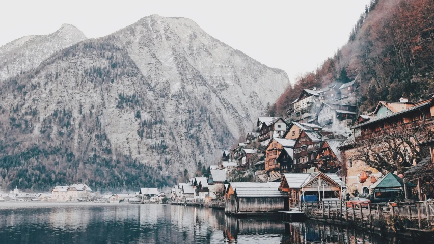 the mountain is covered in snow with a lake in front of it