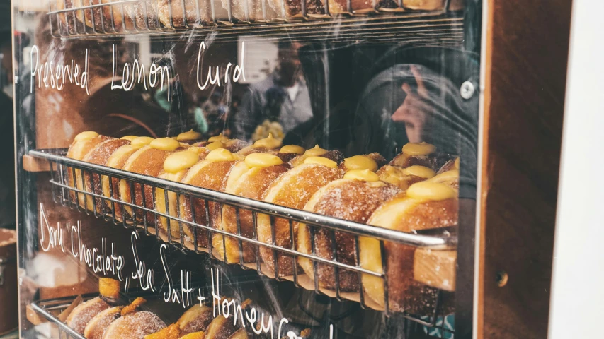 several shelves of doughnuts in a bakery window