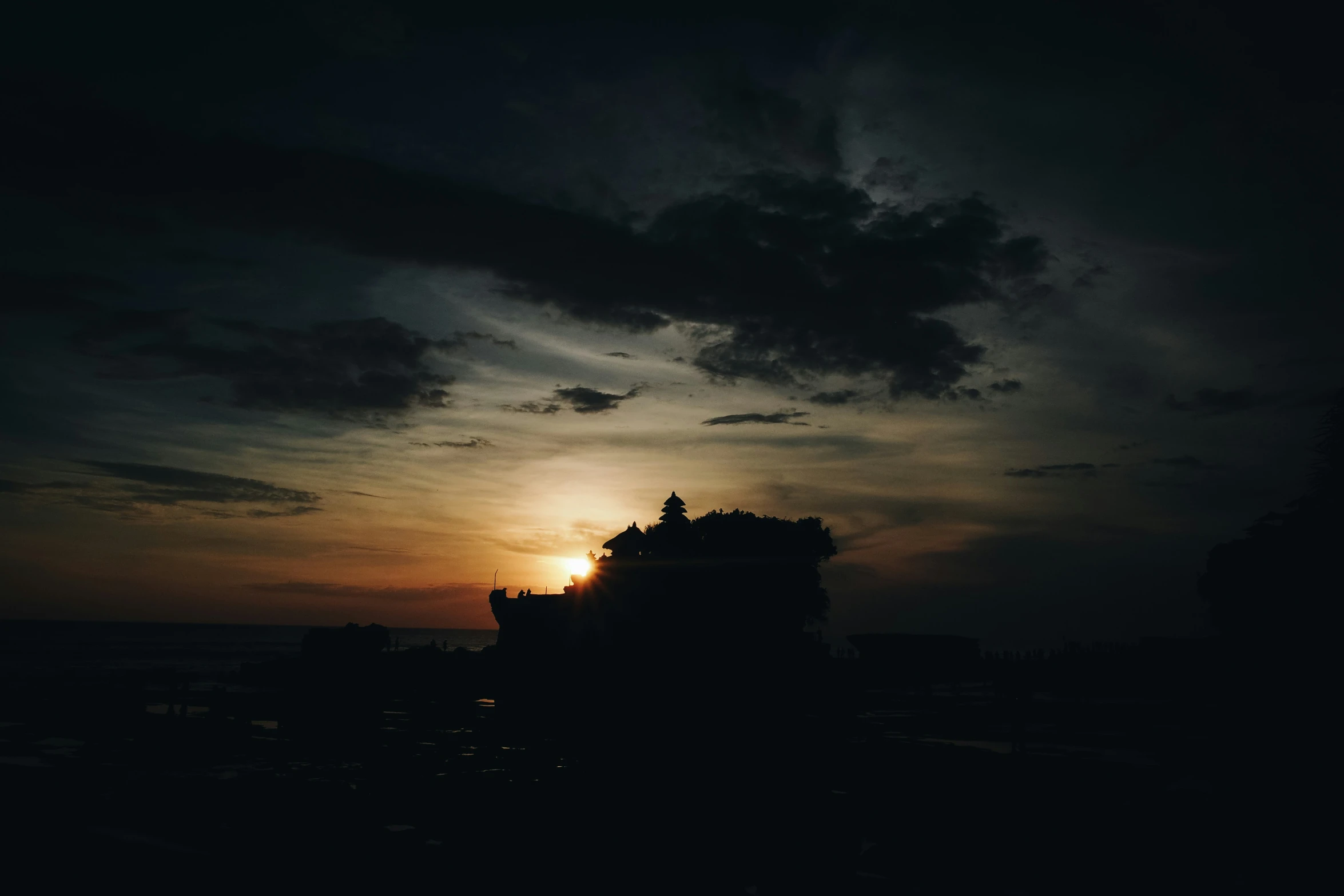 a building in the middle of some clouds at dusk