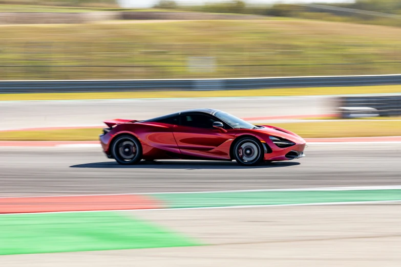 a small sports car speeding on an empty track