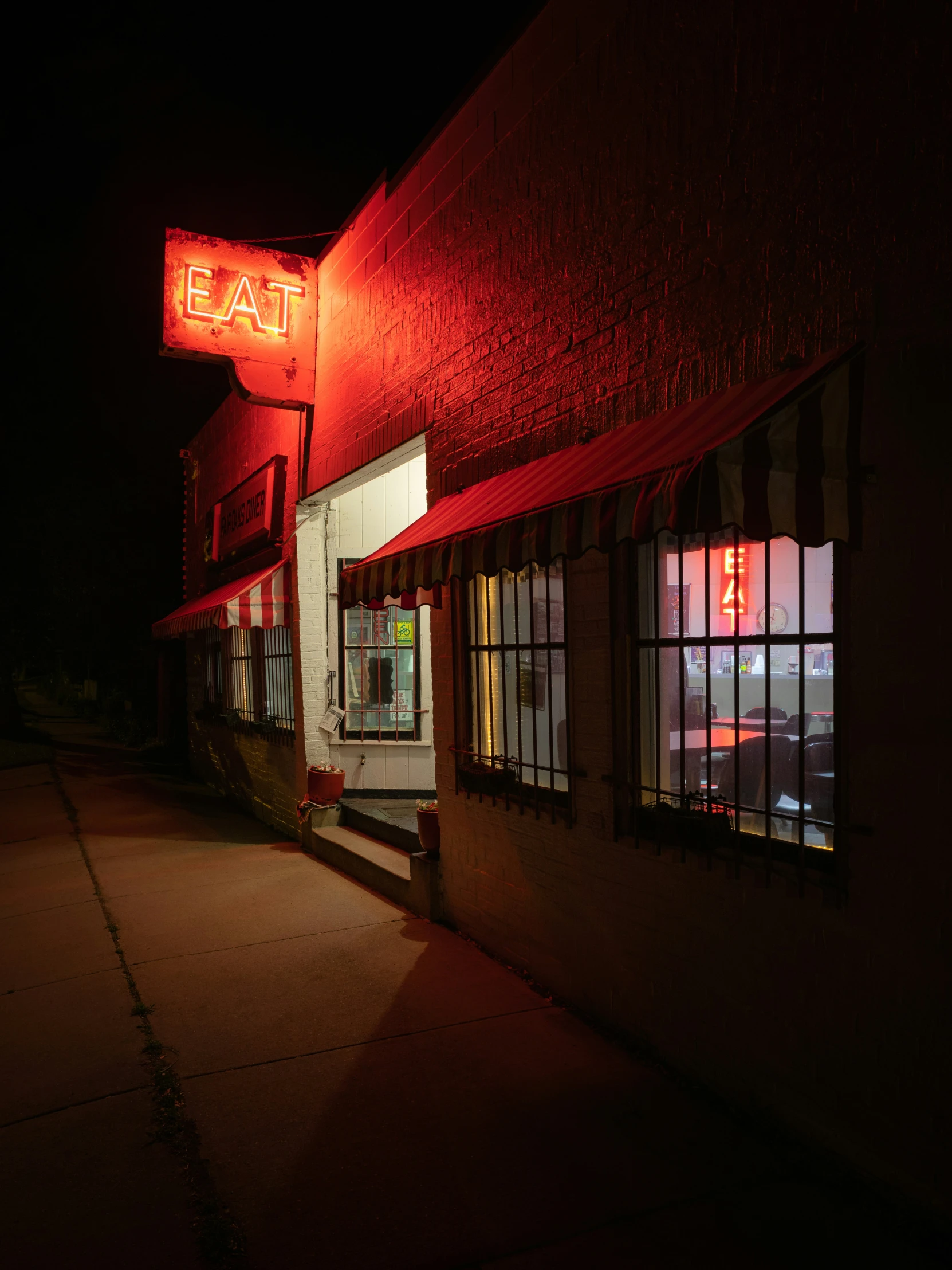 a restaurant sits brightly lit at night time