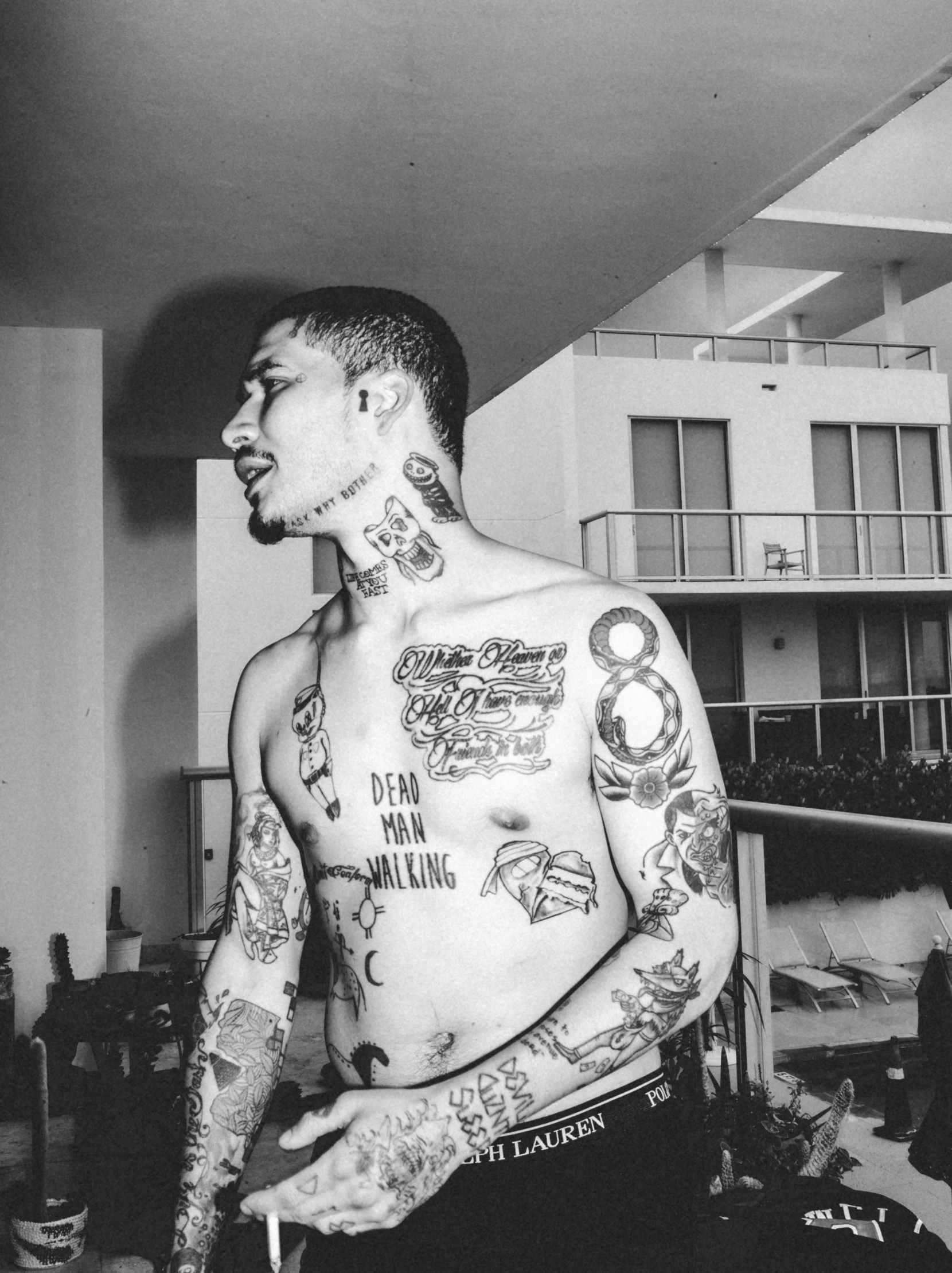 man with multiple tattoos standing inside a room
