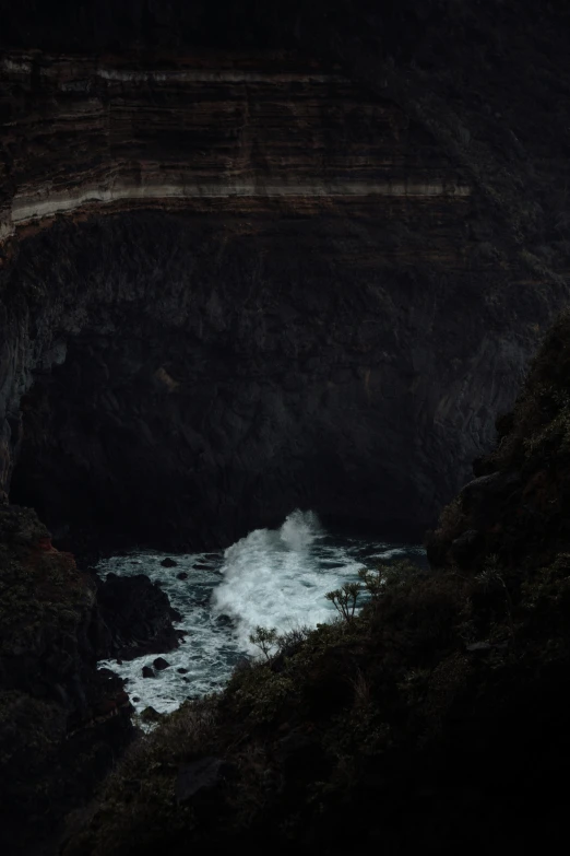 a bird sits on the edge of a dark cliff