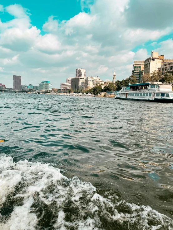 a boat floating along the shore with buildings in the background