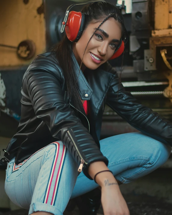 a young woman with headphones sitting on the ground