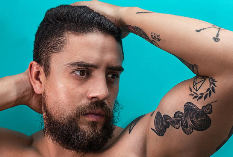 a bearded man with a beard and tattoos posing for the camera