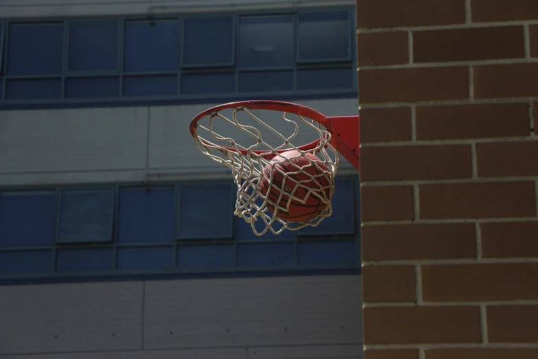 an upside down basketball net near a building