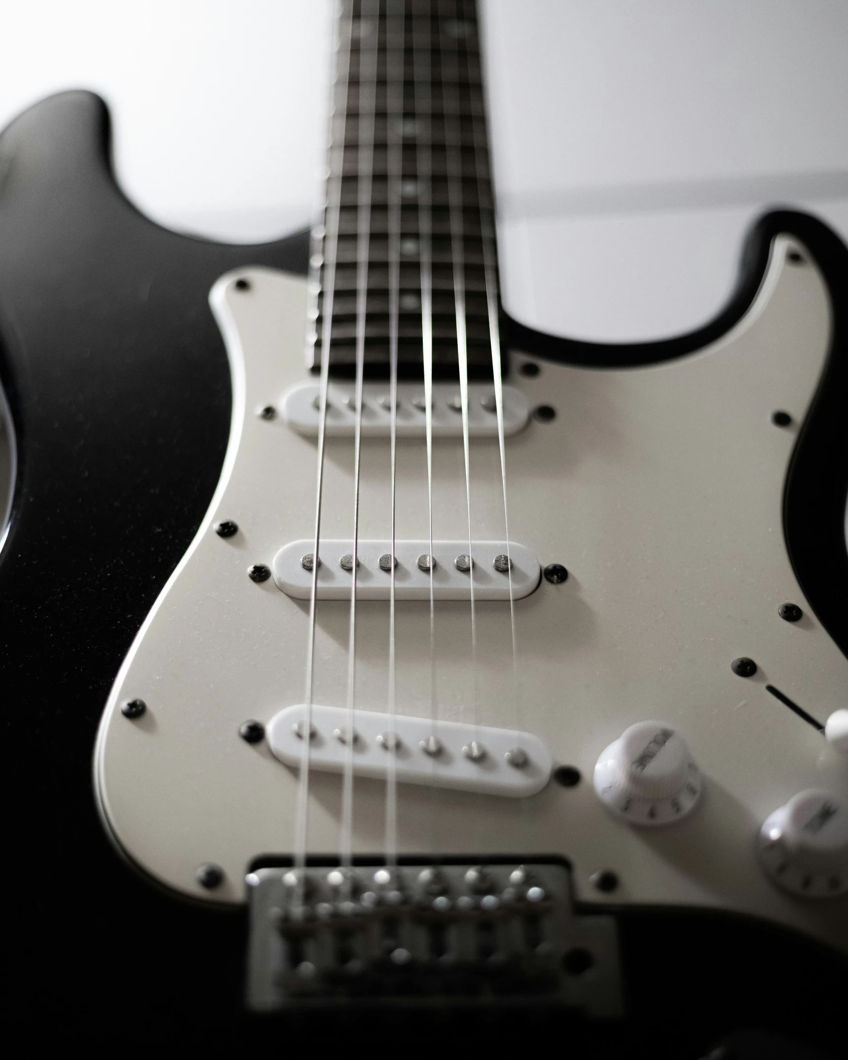 an electric guitar sits upright on a white background