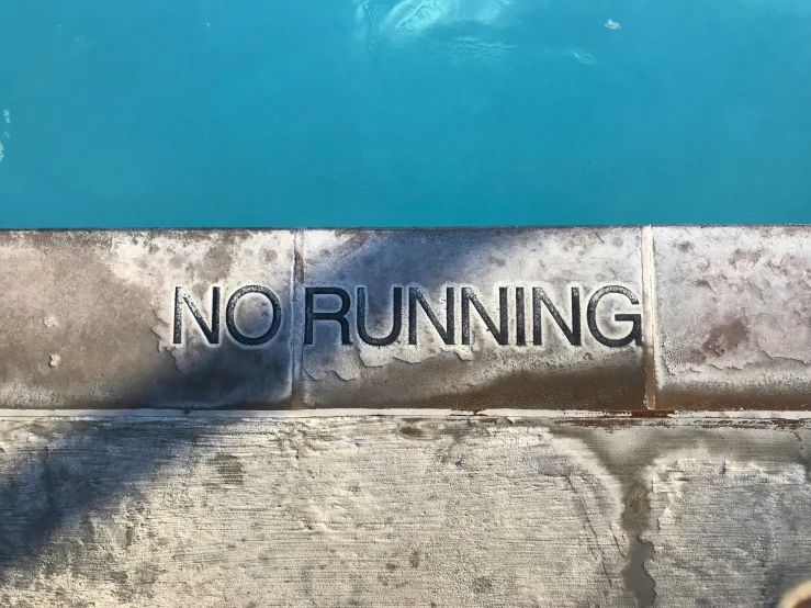 the word no running is written on a concrete barrier