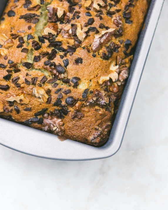 cake with nuts and raisins is in a dish