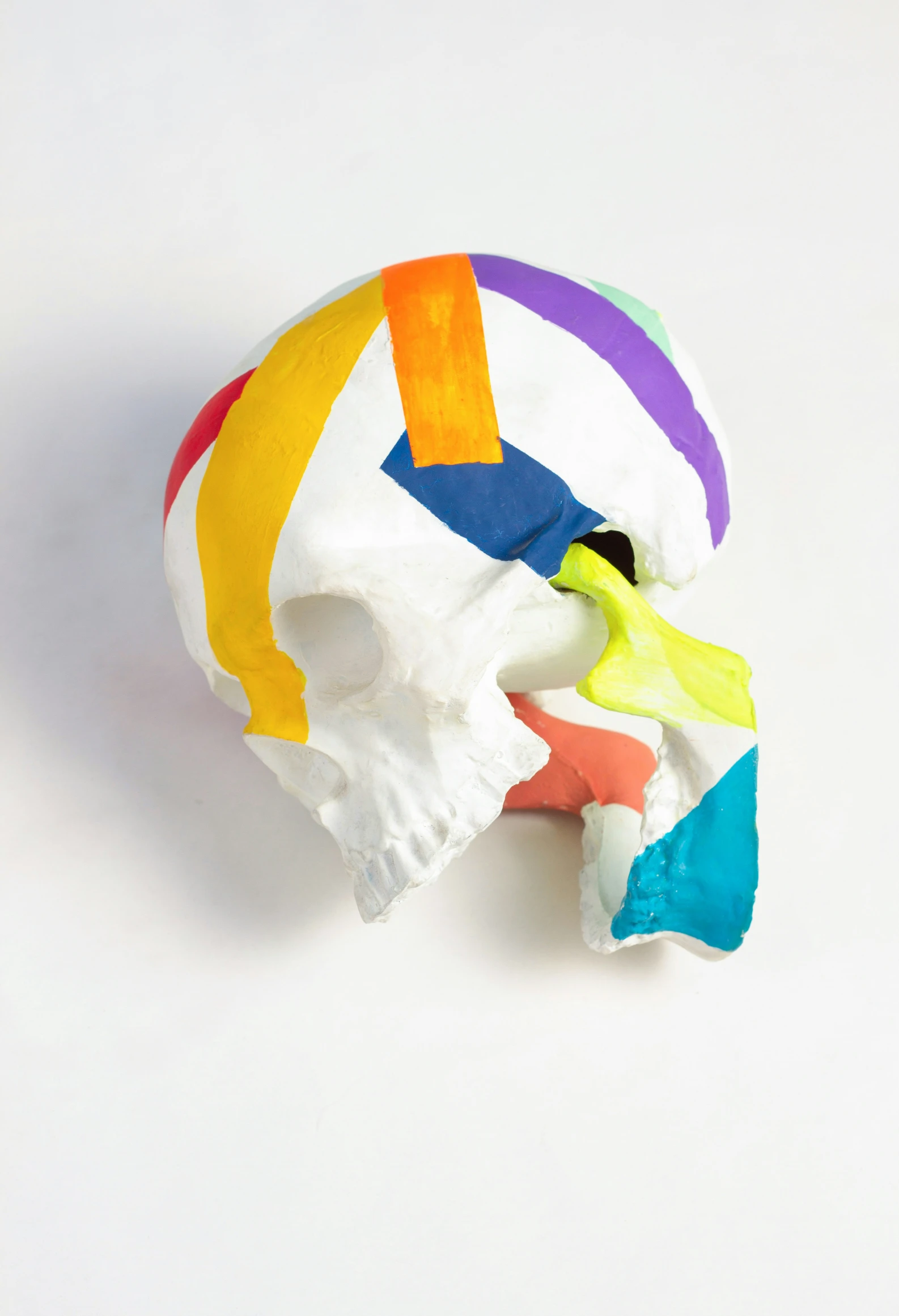 a white and colorful skull sits on a table