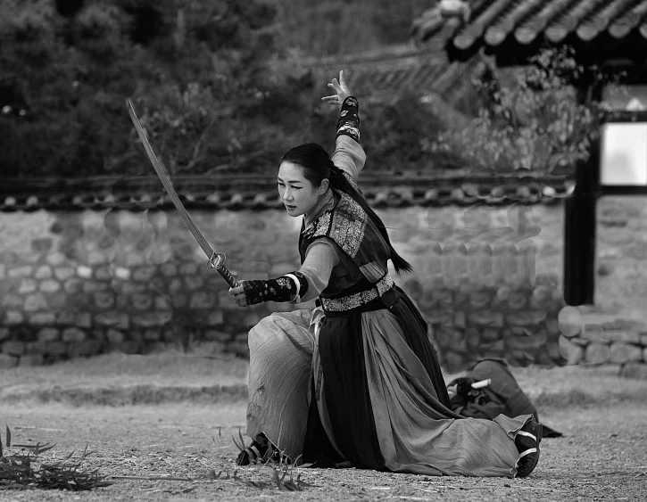 an asian woman dressed in costume holding two swords