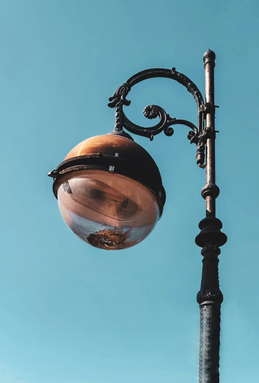 a light pole against a blue sky with an empty lamp
