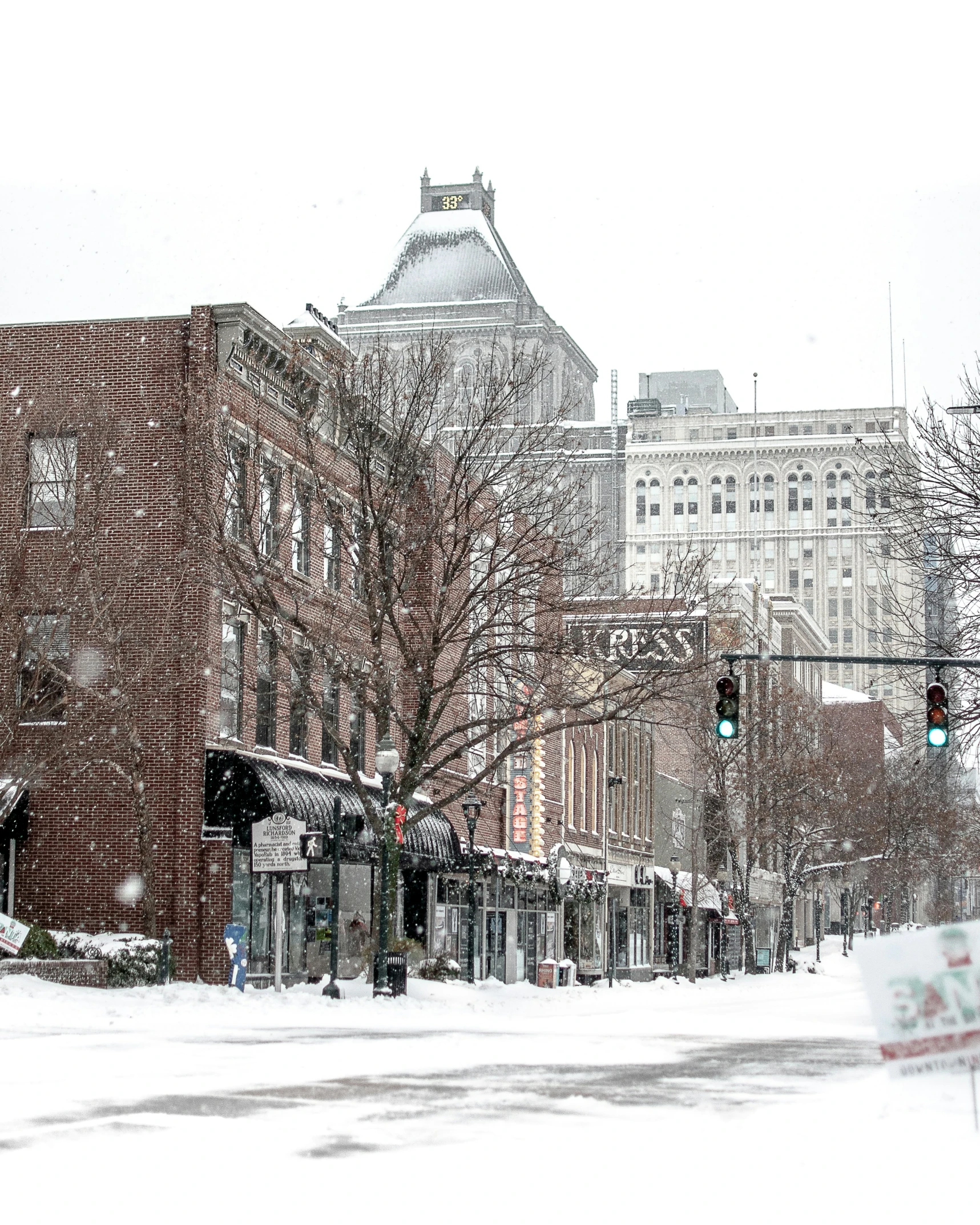 a snow covered city street lined with tall buildings