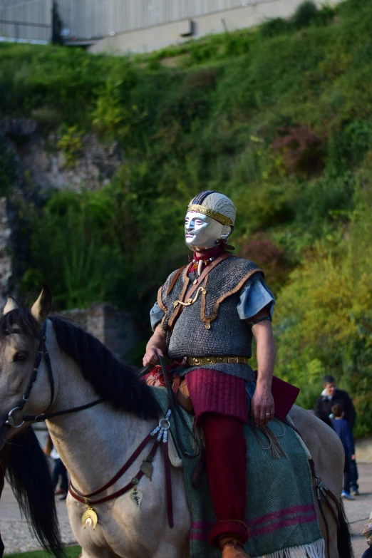 a man in the traditional way of riding a white horse