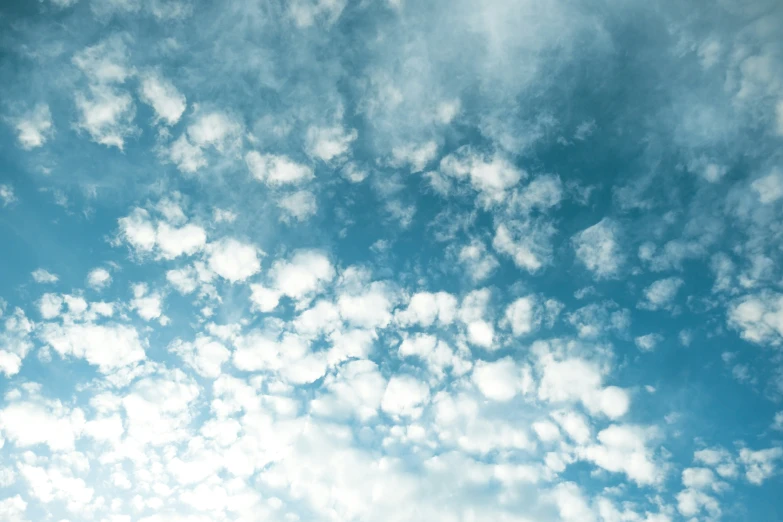 a blue sky with some clouds and an airplane